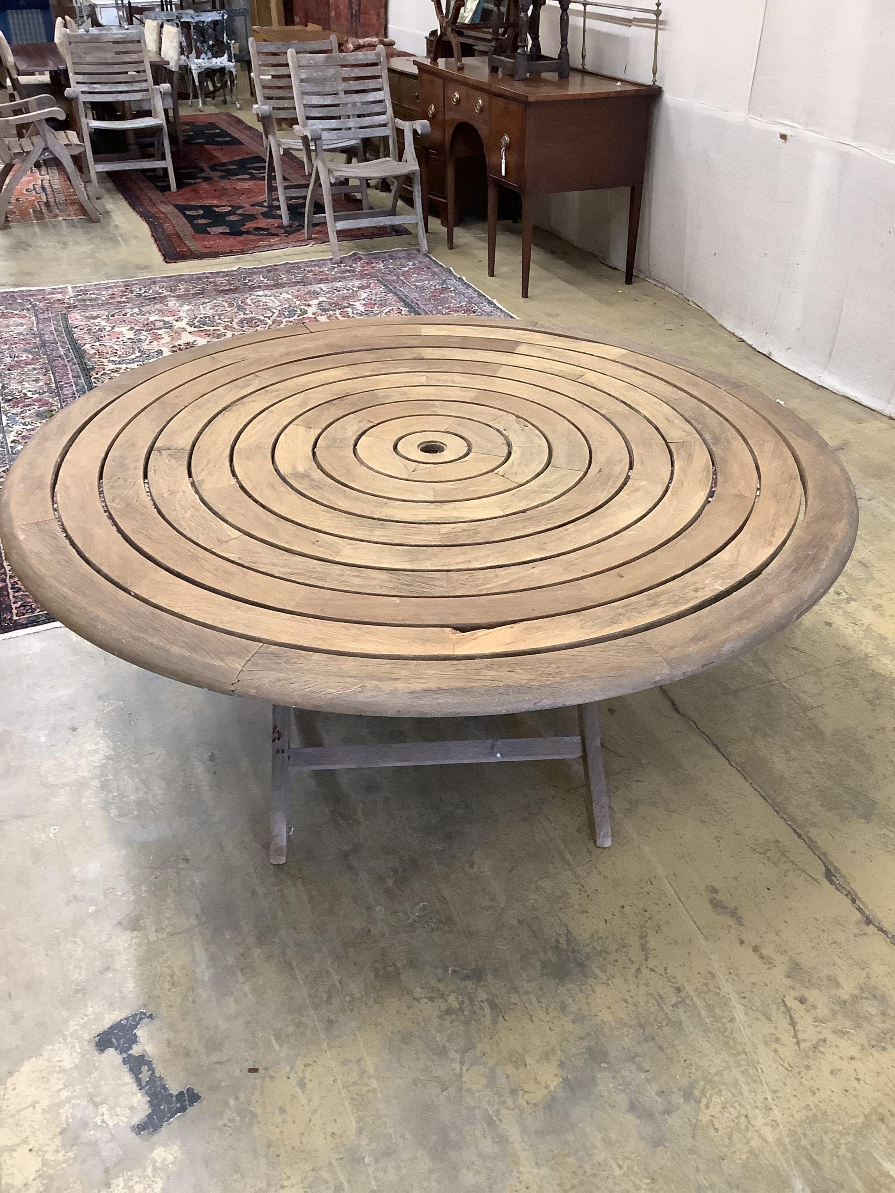 An Alexander Rose circular teak folding garden table with a set of four folding chairs. Condition - table fair, chairs more notably weathered